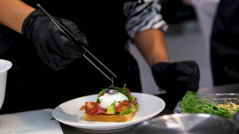 Chef plating food with precision in a restaurant kitchen